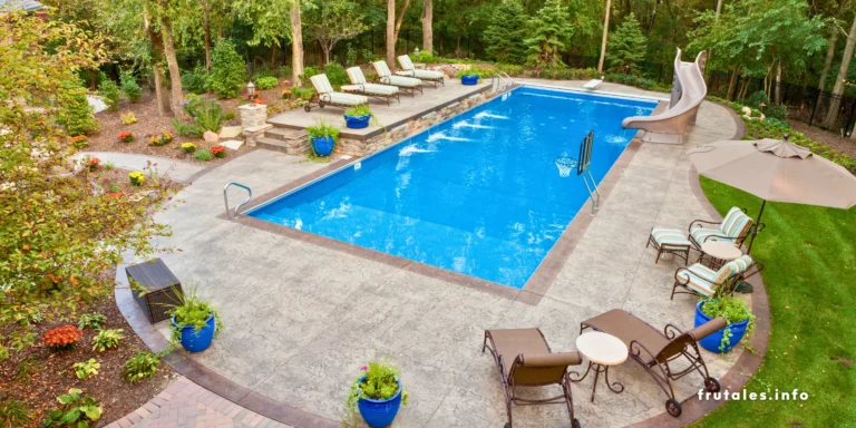 Árboles para piscina al aire libre con sillas reclinables y vegetación circundante, vista desde arriba.